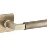 Deurklink op geveerd rozet verdekt Bauhaus messing antiek